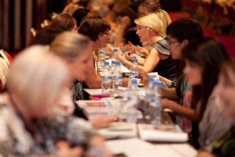 Women sitting at tables talking at a speed networking event