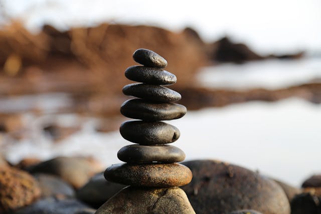 Rocks stacked on top of one another with water in the background.